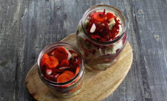 Paunang hugasan at isterilisado ang mga garapon ng salamin. Ilagay ang repolyo, beets, karot at bawang sa mga ito sa mga layer, i-compact nang mabuti ang mga gulay.