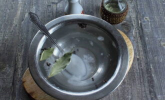Ihanda ang marinade. Ibuhos ang tubig sa kawali, palabnawin ang asin at asukal sa loob nito, magdagdag ng dahon ng bay at paminta, ibuhos sa langis ng gulay. Ilagay ang atsara sa apoy, pakuluan, magdagdag ng suka at alisin mula sa kalan.