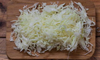 Cum se prepară o salată de varză, ardei și morcovi pentru iarnă? Să începem cu varza. Îndepărtați frunzele de sus și clătiți bine sub jet de apă. Apoi, uscați-l cu un prosop de hârtie sau de bumbac. Acum toacă-l mărunt cu un cuțit sau folosește un robot de bucătărie. Nu uitați să tăiați tulpina. Transferați varza tocată într-un castron adânc.