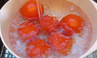 Com preparar tomàquets en escabetx en pots per a l'hivern? Primer, esbandiu bé els tomàquets sota aigua corrent i assequeu-los amb una tovallola de paper. A continuació, tallem el nucli perquè la salmorra penetri més fàcilment a l'interior.