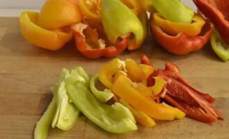 Cum se prepară ardeii în ulei pentru iarnă? Să pregătim componenta principală a viitoarei gustări - ardeiul. Spălăm bine fiecare fruct sub jet de apă, scoatem semințele și tăiem fâșii de aproximativ 1 centimetru lățime.