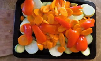 Snij de schone courgette, wortels en paprika in willekeurige kleine stukjes, doe ze in een ovenschaal en giet er plantaardige olie overheen. Bak anderhalf uur op 200 graden. 