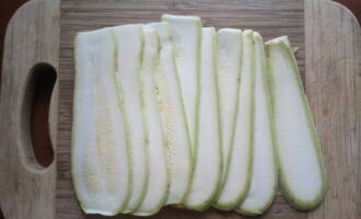 Ta lite salt och smörj den första skivan med det. Vi gör samma sak med de återstående plattorna. Lägg genast zucchinin i en djup tallrik och låt stå i 15 minuter. Under denna tid kommer juice att släppas, som måste tömmas.