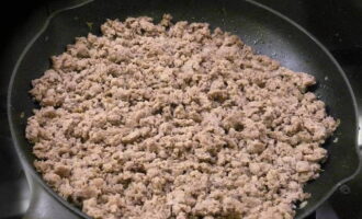 Trimitem carnea tocată în aceeași tigaie la prăjit. Se mai adauga putin ulei vegetal si se prajeste aproximativ 10 minute, despartindu-l cu o lingura. Lasam carnea tocata finita sa se raceasca putin. În acest moment, se rade brânza pe o răzătoare grosieră și se toacă mărunt verdeața. Acum luăm un recipient potrivit, punem acolo carne tocată, dovlecel prăjit cu ceapă și usturoi, brânză rasă și ierburi. Se adauga sare si piper negru dupa gust si se amesteca bine.