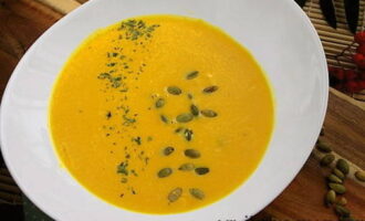 La delicada sopa de crema de carbassa segons la recepta clàssica està a punt. Abocar en bols, decorar amb julivert sec i llavors de carbassa i provar!
