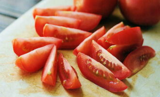 Tvätta tomaterna. Torka grönsaken torr och skär i små skivor. Under skärprocessen tar vi bort stjälkarnas fästpunkter. Lägg alternativt en liten mängd fyllning (en tesked) på varje skiva, lägg en skiva tomat och en örtkvist ovanpå (vi tvättar först gänget och tar isär det till kvistar). 