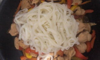 Adăugați udonul fiert la puiul pregătit și amestecați din nou vasul.