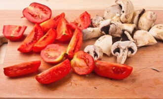 Gupitin ang mga champignon at mga kamatis sa quarters.