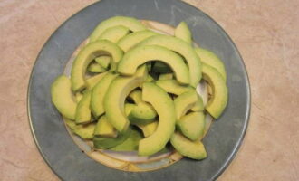 Schil de avocado en snij in dunne plakjes.