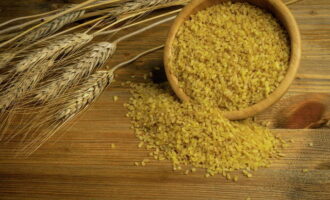 Tillsätt bulgur snabbt i löken och fräs under konstant omrörning i flera minuter. 