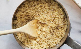 Bulgur med lök hälls med vatten och saltas lätt och får sedan sjuda på låg värme under lock i 6 minuter. 