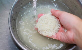 Com cuinar una cassola d'arròs al forn? Primer, esbandiu bé l'arròs sota aigua corrent fins que quedi clar.