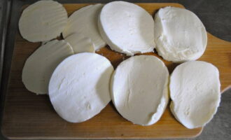 Com fer una clàssica amanida caprese italiana amb mozzarella i alfàbrega? Primer, talleu la mozzarella a rodanxes de gruix mitjà.