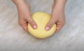 Het deeg moet worden gekneed zodat het iets zachter en elastischer wordt. Als het moeilijk is om dit in één keer te doen, doen we het in een paar benaderingen, waarbij we het deeg tien minuten laten rusten, afgedekt met een kom.