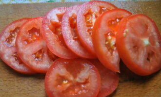 Renteu bé els tomàquets sota aigua corrent i assequeu-los amb una tovallola de paper. A continuació, talleu la tija i talleu-la en cercles del mateix gruix que la mozzarella.