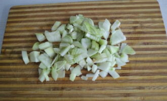 Com cuinar blat sarraí amb guisat en una paella? Primer, netegem i rentem les cebes i les tallem a daus petits.