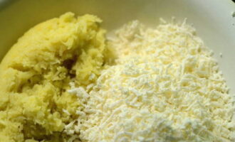 Sa oras na ito, ihanda ang pagpuno para sa mga khychin. Grate ang keso (maaari mong gamitin ang Adyghe cheese). Balatan ang mga patatas, pakuluan hanggang malambot, pagkatapos ay palamig sa temperatura ng silid. Susunod, lagyan ng rehas ito sa isang pinong kudkuran o ipasa ito sa isang gilingan ng karne.