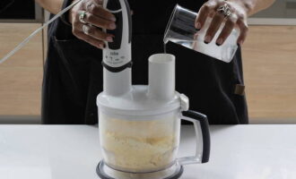 Mentre tritureu els ingredients, aboqueu-hi aigua amb gel a poc a poc. La massa ha de ser gruixuda, separar-se fàcilment dels costats del bol i enrotllar en una bola.