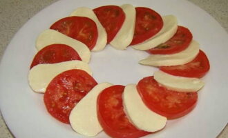 Ara agafeu un plat rodó adequat i hi poseu-hi mozzarella i tomàquet tallats, alternant-los entre ells.