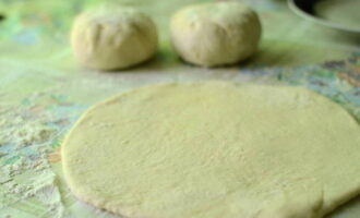Ngayon ay patagin namin ang nagresultang bola, pagkatapos nito ay maingat naming igulong ito sa isang manipis na flat cake ang laki ng aming kawali.