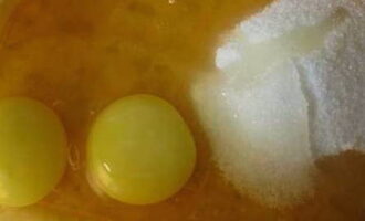 Hoe maak je luchtige zure roompannenkoekjes in een koekenpan? Breek de eieren in een kom, voeg zout en suiker toe en klop de ingrediënten.