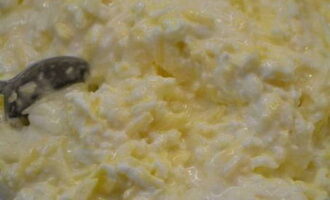 Magdagdag ng 5 tablespoons ng sour cream sa ginutay-gutay na keso at talunin sa 4 na itlog - ihalo nang maigi hanggang sa makinis.