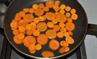Skala morötterna, skär i skivor och stek i vegetabilisk olja i 5-6 minuter. Häll sedan i lite vatten och låt puttra i ytterligare 5-6 minuter.