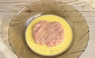 Amb les mans mullades, dividim la carn picada en boles iguals. A continuació, doneu a cada bola una forma plana amb vores llises. Submergeix el schnitzel format per ambdós costats a la lezone. 