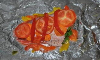 Gnid in fisken med salt och kryddor och lägg dem på folie. För varje abborre, lägg flera skivor paprika, tomatskivor och stuvade morötter. 