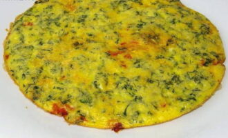 Serveer de afgewerkte frittata warm, bestrooid met gedroogde kruiden en vergezeld van plakjes verse tomaat.