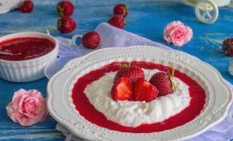 Serviți blancmange-ul congelat la masă, acoperit cu sos de căpșuni.