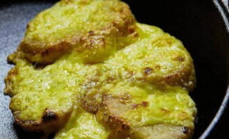 Doe de aardappelen in een gietijzeren koekenpan of ovenschaal, bestrooi met geraspte kaas en plaats ze 15 minuten in de oven op 180 graden. Bereid het bijgerecht voor totdat de kaas gebakken is.
