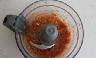 Hoe Armeense lamajo thuis koken? Voeg om te beginnen tomatenpuree, fijngehakte uien en gepelde teentjes knoflook toe aan een blenderkom. Maal alles totdat je een saus krijgt.