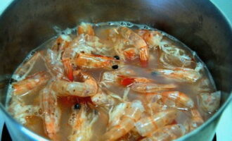 Com fer una amanida amb gambes i pinya? Aboqueu aigua en una cassola mitjana, poseu-la al foc, afegiu-hi sal i deixeu-ho bullir. En aquest moment, esbandiu bé les gambes amb aigua corrent tèbia i poseu-les en aigua bullint. Tornar a bullir tot, tapar la cassola amb una tapa i coure les gambes durant 6-7 minuts. Si són grans, llavors - 10. El més important és no cuinar-los massa perquè no es tornin gomosos.
