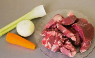 Hoe maak je heerlijke lamssoep? We beginnen met koken door de bouillon te koken. Om het te bereiden, spoelt u de botten en het vlees grondig af onder stromend water en doet u het in een grote pan, vult u het met koud water en zet u het op het vuur. Breng op laag vuur aan de kook. Verwijder na het koken het schuim met een schuimspaan en voeg een gepelde ui, een wortel en een stengel bleekselderij toe - laat op laag vuur anderhalf uur sudderen onder een gesloten deksel.