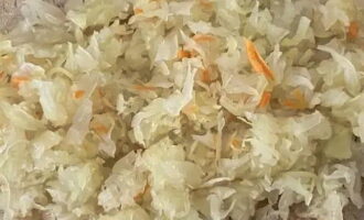 Com cuinar pastissos de pasta de full al forn? Primer, traieu el suc del xucrut: premeu-lo lleugerament amb les mans. Després talla a trossos petits.