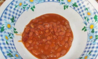 Ang salad na may de-latang pulang beans ay napakadaling ihanda. Buksan ang lata ng beans at ibuhos ang mga nilalaman sa isang malalim na plato.