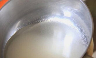 Ibuhos ang asukal sa isang maliit na lalagyan ng metal. Nagbuhos din kami ng tubig dito.