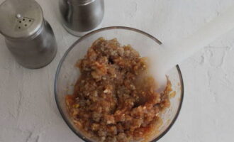 Doe het varkensgehakt in een geschikte bak, voeg de resulterende tomatensaus, zout en gemalen zwarte peper eraan toe en meng alles grondig met een spatel. Bedek de container vervolgens met huishoudfolie en plaats deze een uur in de koelkast.