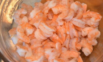 Col·loqueu les gambes acabades en un colador, deixeu-les refredar una mica, després netegeu-les, traient-ne el cap, la cua i la closca. Després ho posem en un plat. Si les gambes són grans, podeu tallar-les en 2-3 parts.