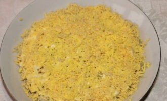 Pakuluan ang mga itlog ng manok, alisan ng balat at hatiin sa mga puti at pula. I-chop ang mga yolks at ilagay sa pangalawang layer.