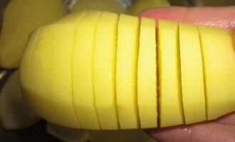 Amb un ganivet afilat fem talls en forma d'acordió a cada patata, però no tallem del tot perquè el tubercle quedi intacte a la base. Per comoditat, podeu col·locar la patata en una cullerada i tallar-la per sobre; les vores de la cullera no us permetran tallar la patata fins al final. Espolseu cada patata amb sal i pebre negre mòlt al gust.