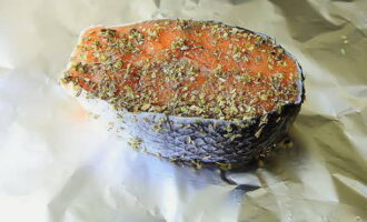 Leg de zalmsteaks op folie en vet ze aan alle kanten royaal in met een mengsel van kruiden.