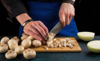 Snij champignons en uien in kleine blokjes.