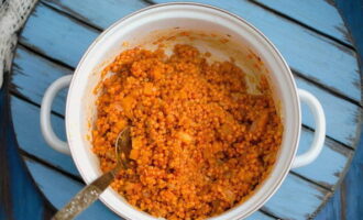 Cand usturoiul incepe sa-si elibereze aroma, adauga pasta de rosii si amesteca. Apoi, adăugați lintea roșie și amestecați totul din nou bine.