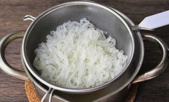 Kook de rijstnoedels gaar en doe ze in een vergiet. Kook de rijstnoedels gaar en doe ze in een vergiet.