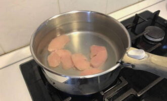 Hoe maak je een eenvoudige en heerlijke aardappelsoep? Was de kipfilet, hak hem grof, doe hem in een pan, zet hem onder water en laat hem koken. Als het water kookt, schuimt u het schuim af, voegt u de helft van de ui toe en kookt u nog eens 15-20 minuten.