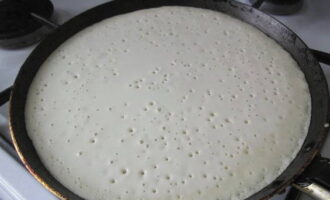 Làm nóng chảo rán với dầu thực vật. Đổ một ít bột vào đây.