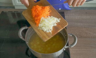 Schil een wortel, was hem en rasp hem op een grove rasp. We schillen ook de uien en hakken ze fijn met een mes. Doe de bereide groenten in een pan met de aardappelen en erwten en voeg naar smaak zout en gemalen zwarte peper toe.
