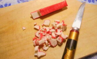 Gupitin ang mga crab stick sa maliliit na cubes.